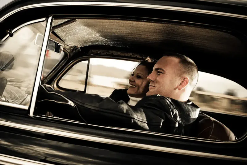 Happy couple enjoying driving their car following panel beating repairs